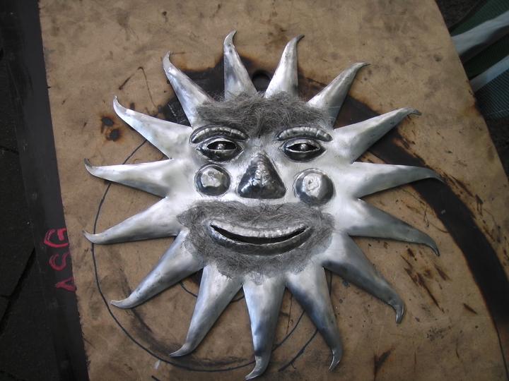 Zon met gezicht in metaal