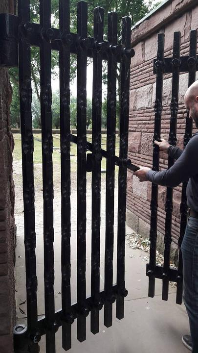 Hoge poort met smeedijzeren spijlen