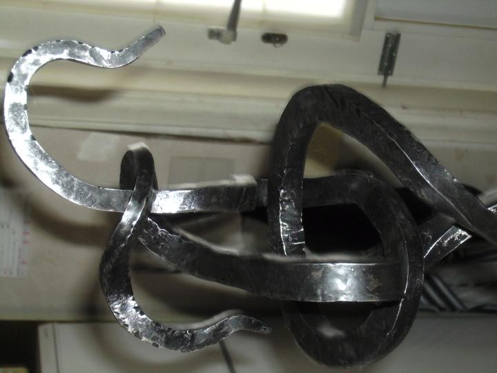 Detail van gesmeed ijzer, in een knoop gebogen