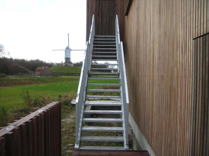 Stalen buitentrap met roostertreden langs een gevel